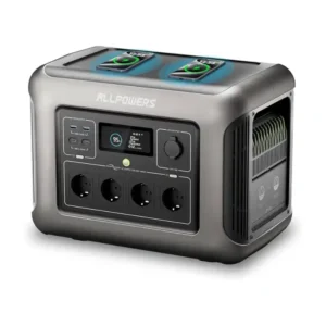 A studio product image of the ALLPOWERS R1500 portable power station, showing its matte black and dark gray rectangular chassis, flat top with integrated carrying handles, central color LCD display, wireless charging pads, and front-facing AC, DC, and USB ports.