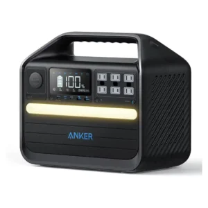 A studio product photo of the Anker 555 PowerHouse portable power station on a white background, featuring its rugged matte-black body, integrated carry handle, front LCD display showing a full battery, six AC outlets, multiple USB ports, and a warm-white LED light bar.