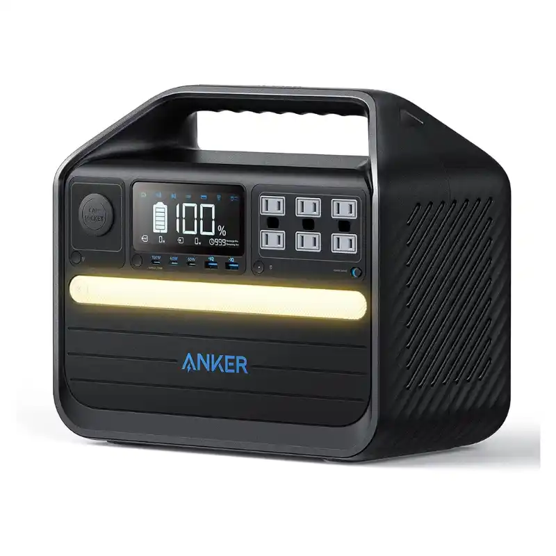 A studio product photo of the Anker 555 PowerHouse portable power station on a white background, featuring its rugged matte-black body, integrated carry handle, front LCD display showing a full battery, six AC outlets, multiple USB ports, and a warm-white LED light bar.