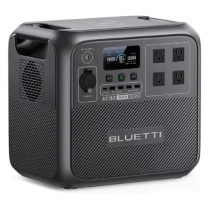 Studio product image of the BLUETTI AC180 portable power station, showing its dark gray composite body, front LCD display, 1,152 Wh battery capacity, AC outlets, USB ports, DC output, and wireless charging pad.