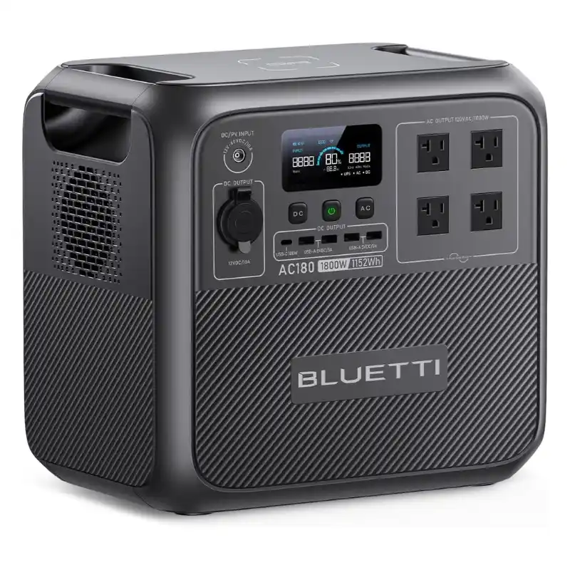 Studio product image of the BLUETTI AC180 portable power station, showing its dark gray composite body, front LCD display, 1,152 Wh battery capacity, AC outlets, USB ports, DC output, and wireless charging pad.