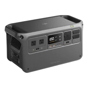 DJI Power 1000 portable power station in a studio shot against a white background, showing its dark grey body, integrated handles, front LCD screen displaying 100% battery, USB ports, AC outlets, and SDC drone charging ports.
