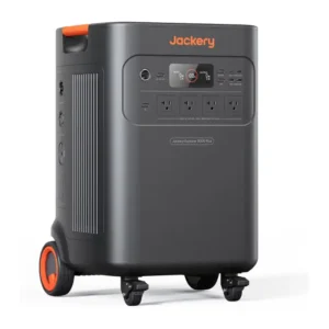 A studio product photo of the heavy-duty Jackery Explorer 5000 Plus portable power station on a white background, showing its grey-and-black suitcase-style body with an orange pull-rod telescoping handle extended vertically, a front color LCD screen, and integrated double transport wheels.