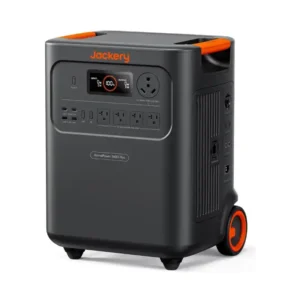 A studio product photo of the Jackery HomePower 3600 Plus portable power station on a white background, showing its dark gray chassis, bright orange carry handles and wheel accents, front LCD display, side charging ports, USB outputs, AC outlets, and integrated transport wheels.