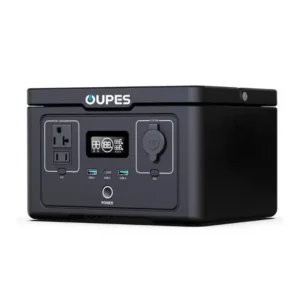 A studio product photo of the compact OUPES 600 portable power station on a white background, displaying its solid black rectangular body, front LCD screen showing battery levels, dual AC outlets, and various USB and DC ports.